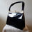 Thumbnail: Black patent handbag with rigid handles