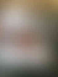 Round table set with white table cloth and red floral arrangement.