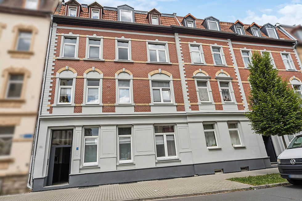 Wielopiętrowy budynek z czerwoną ceglaną fasadą i białymi ramami okiennymi, łączący historyczną architekturę z zakrzywionymi