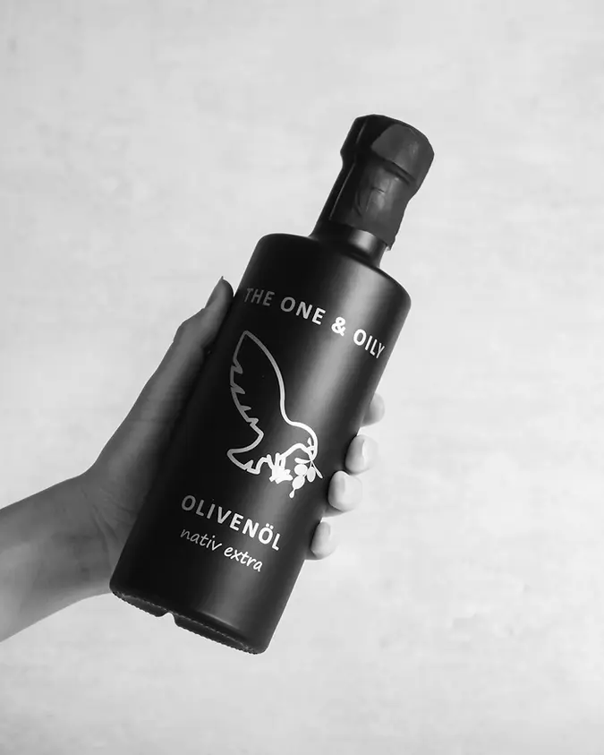 Produktfoto the one and oily Olivenöl von einer Hand gehalten