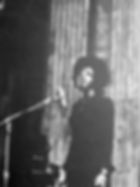 Black female singer at the mic.