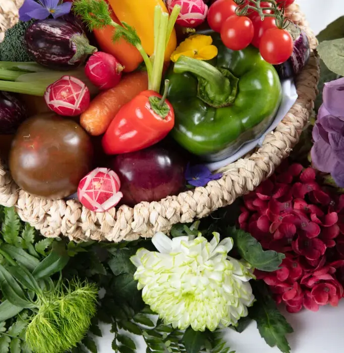 luxury private jet dining fresh farm-to-table vegetables basket with bell peppers, cherry tomatoes, radishes, carrots, and eggplants