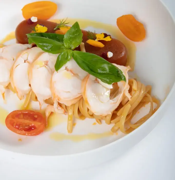 luxury private jet dining gourmet lobster pasta with basil and heirloom tomatoes