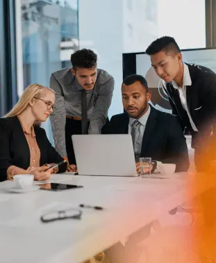 Grupo de profesionales trabajando con laptops en una sesión de planificación estratégica y colaboración digital.