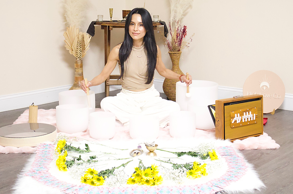 Photo of High Love Collective's Sound Practitioner Aris playing crystal bowls.