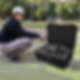 Miniaturbild: Man examines camera lenses in a hard case on a field