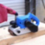 Blue belt sander on wood