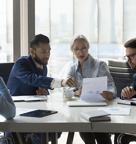 Serious multiracial older and young businesspeople gathered in boardroom discuss financial
