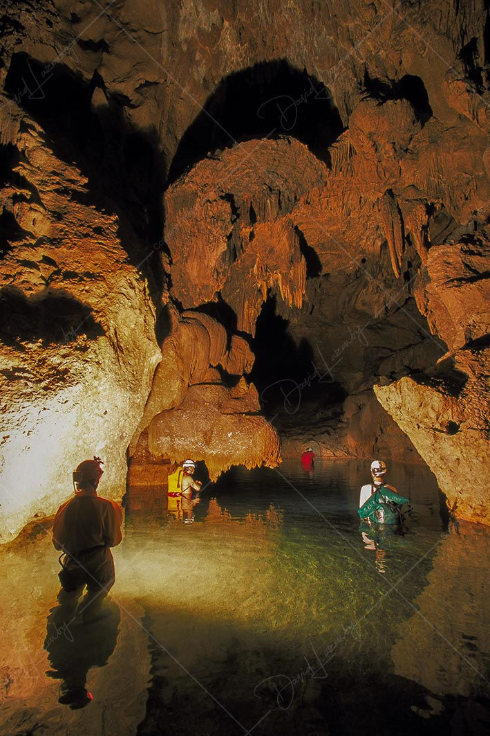 Cavers in river passage