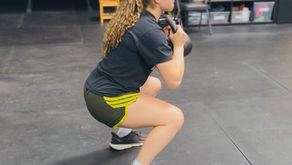 an athlete lifting kettlebell weights in squat position
