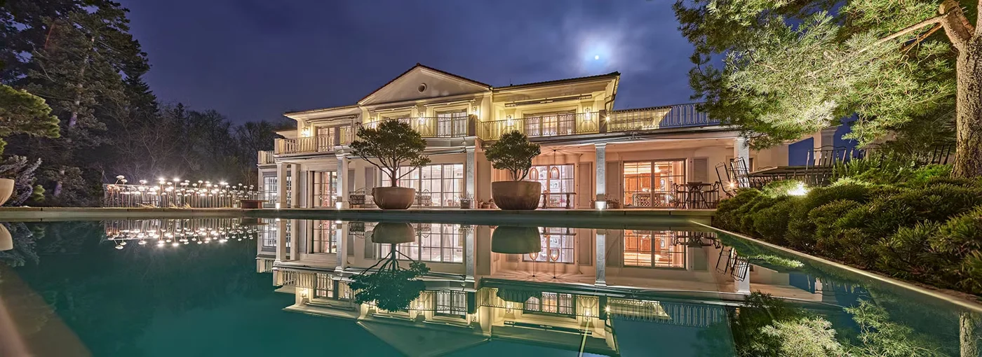 Beleuchtete Villa mit Pool bei Nacht, Architekturfotografie