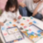 A child playing with the wooden alphabet and number matching flashcard game at a table.