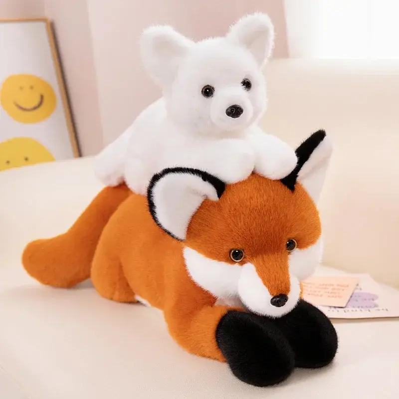 A pure white arctic fox plush toy resting playfully on the back of a classic orange and white red fox plush toy.