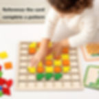 A child's hands placing colourful geometric blocks onto the wooden mosaic grid board.