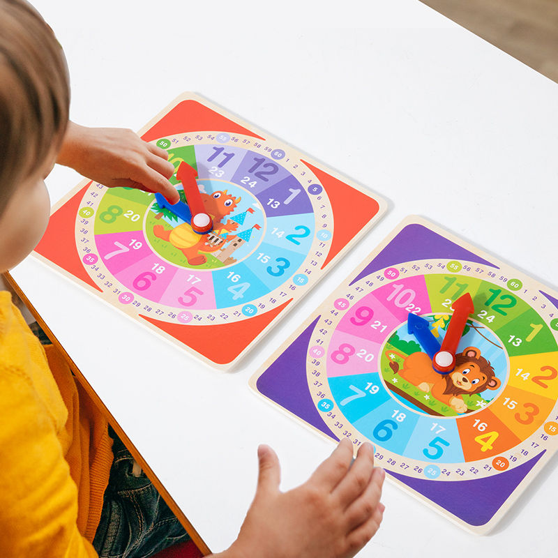A child in a yellow shirt playing with the dinosaur-themed wooden teaching clock
