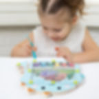 A young child uses the magnetic wand on the dinosaur colour sorting maze toy.