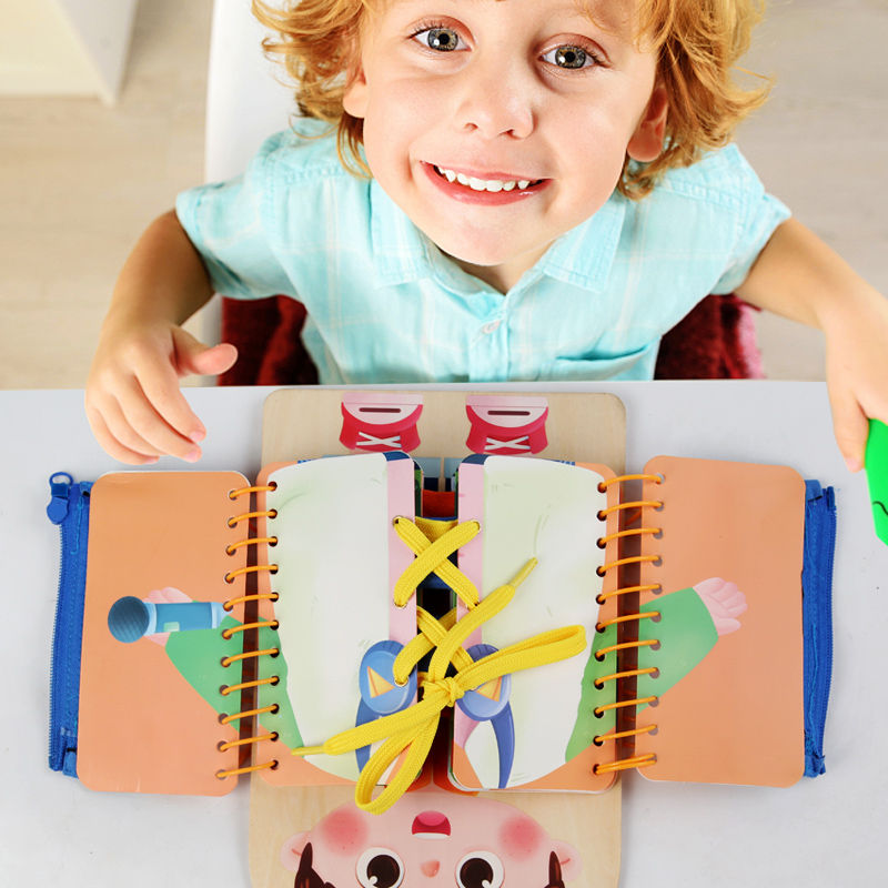 A happy child smiling while playing with the Montessori dressing skills board.