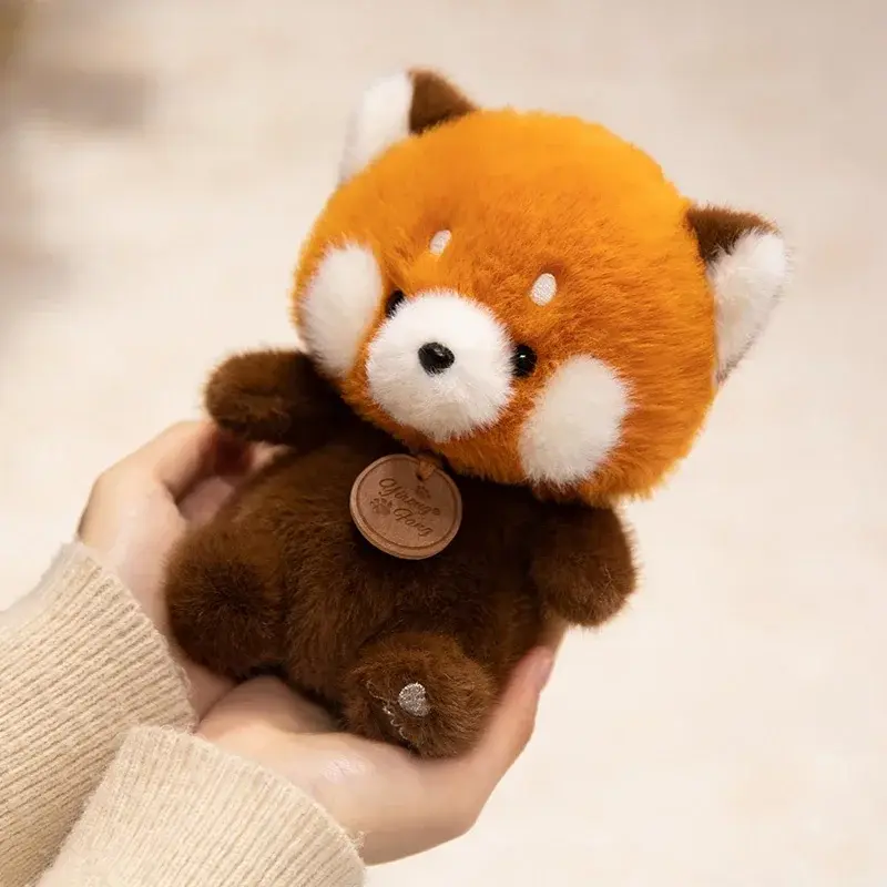 Thumbnail: Close-up of a person's hands gently holding a soft, chubby brown capybara plush toy with a wooden collar