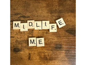 'Midlife Me' written in tiles on a wood background