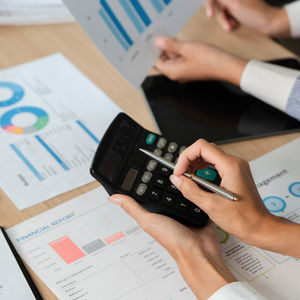 Calculating Financial Metrics. Professionals using a calculator for financial analysis and reports