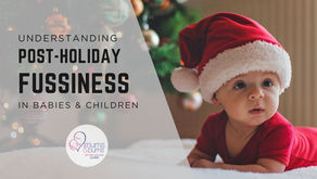 Baby wearing a Santa hat lying on a blanket, illustrating post-holiday fussiness in babies and children.