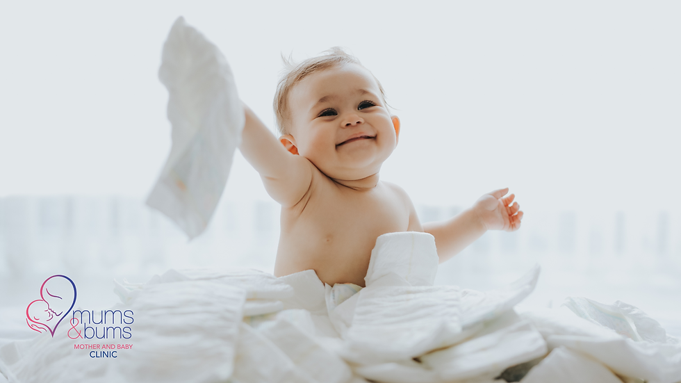 Happy baby surrounded by nappies representing healthy, normal bowel habits and baby development.