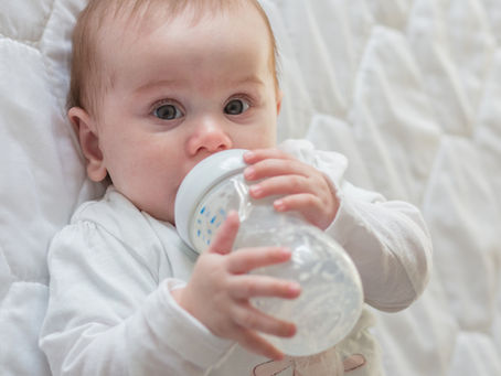 A small baby drinking a bottle.