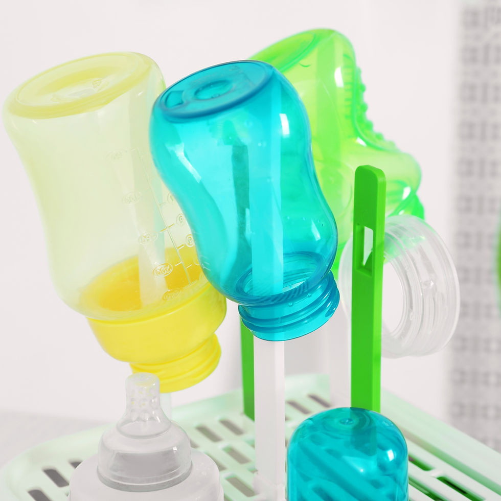 Blue, green and yellow bottles drying on a bottle dry rack.