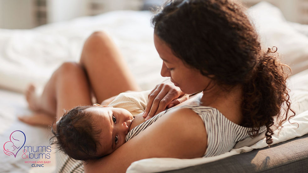 Mother breastfeeding her baby on a bed, showing that breast milk provides all the hydration infants need before 6 months.