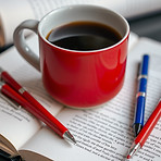 coffee mug, pens, red,, blue, and black, on books_edited.jpg