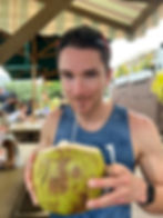 A man drinking out of a coconut