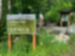 Girl standing next to mailbox peak trailhead sign