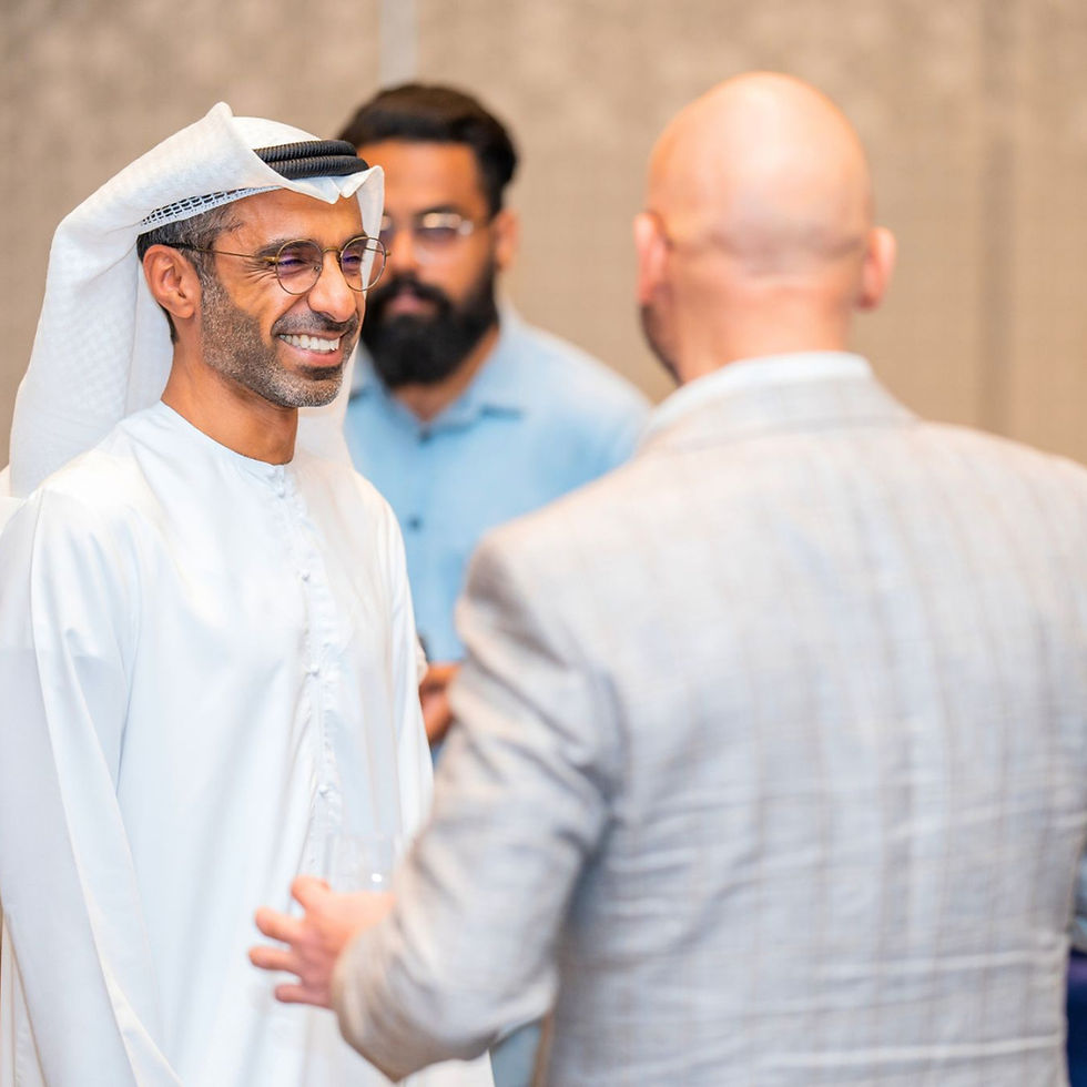 Executive coach Saeed Alghafri smiling during an engaging group coaching conversation