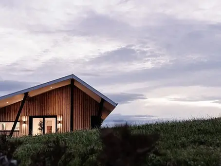 Picture of a house on a grassy hillside.