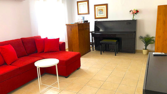 The lounge with sofas piano and bar cabinet at Pleamar 30.