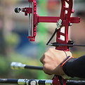 Archery, archery sport and people concept - close up of archer hands with recurve bow and