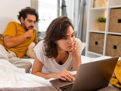 Persona abrumada revisando facturas y deudas acumuladas