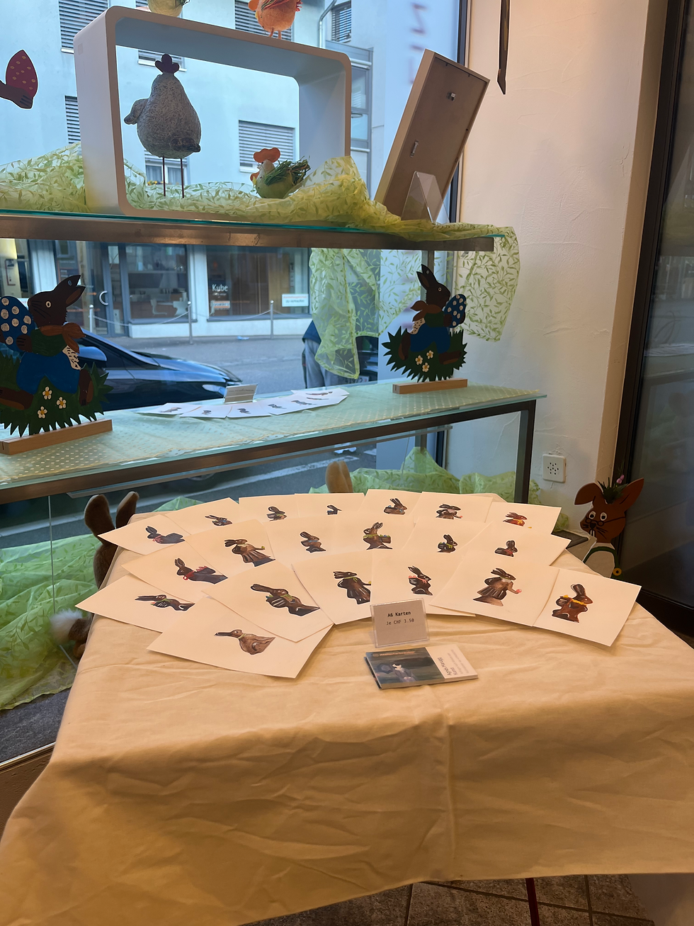 TISCH MIT POSTKARTEN IM VERKAUFSRAUM DER CONFISERIE