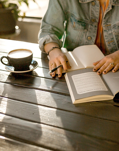 Woman Writing with coffee beside her