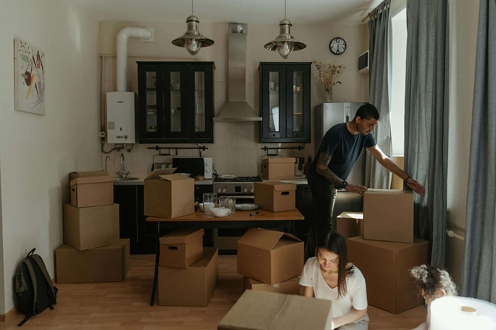 Man in Blue T-shirt Standing Near Brown Cardboard Boxes