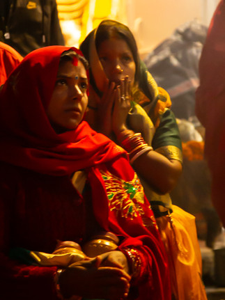 Two Woman pray at a sunrise aarti