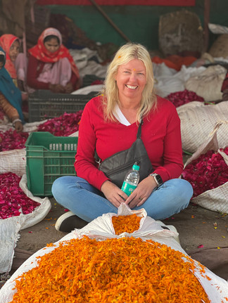 A woman sits at the floral market  of Jaipur