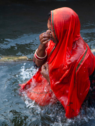 A woman submerges herself in the Ganges River