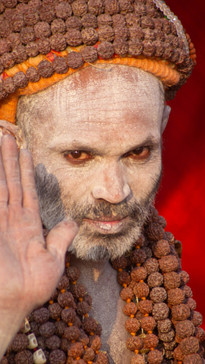 A holy man, covered in ash, waves
