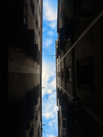 A bright blue sky between two dark buildings