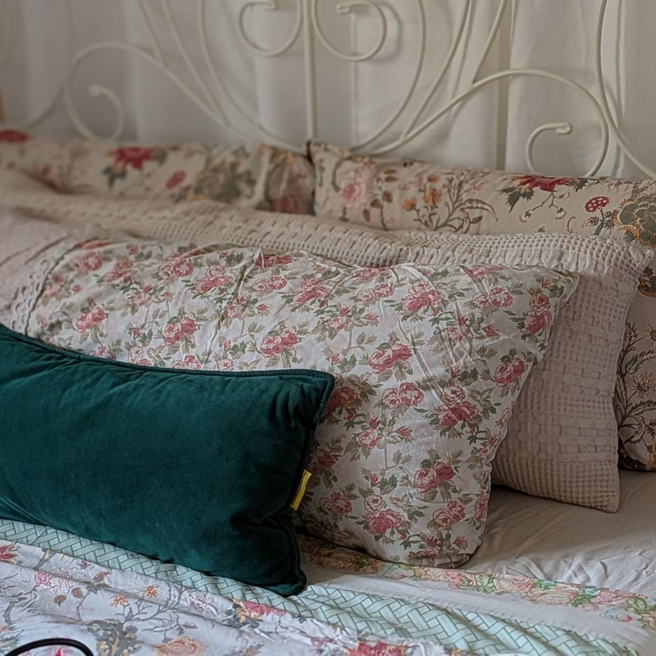 Casa Oz-Shabit: Layered textured cushions and pillows and patterns on bed with canopy fabric showing.
