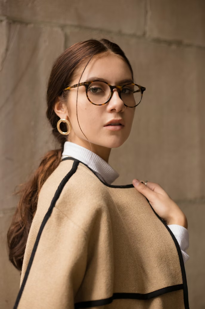 A woman wears her eyeglasses.