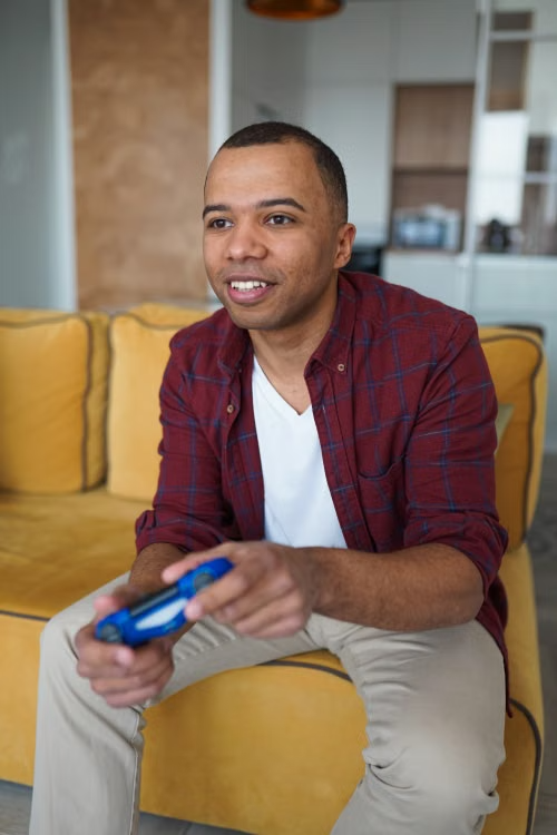 Man sitting on a sofa at home playing a video game