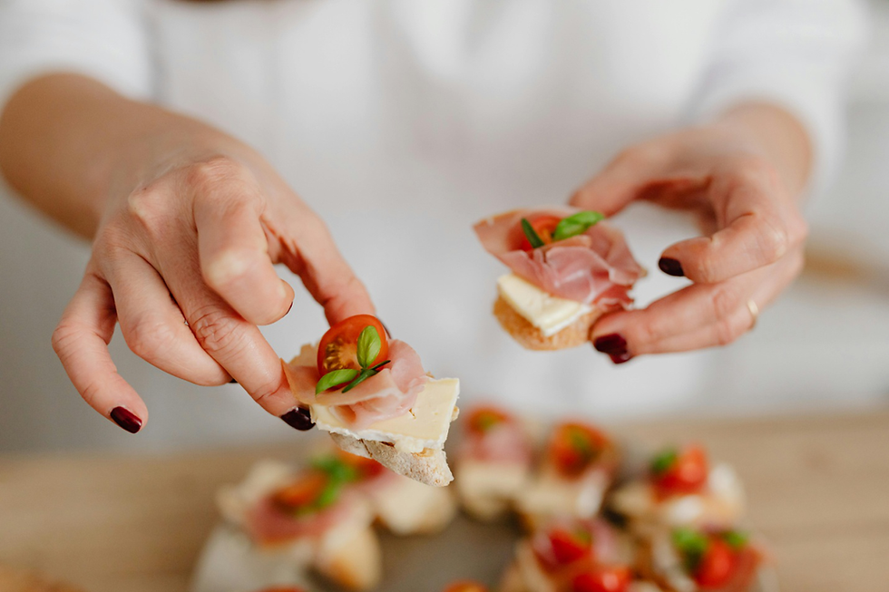 a person holding up two pieces of bread with toppings