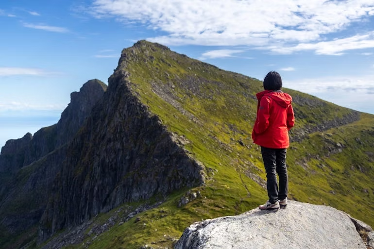 a woman standing on a rock and thinking about managing a creative career while traveling